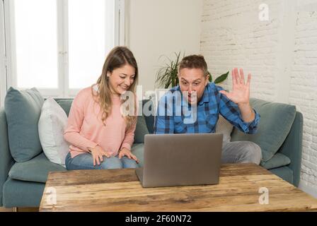 Life at home image of Happy couple video calling friends and family using laptop. Man and woman online chatting in video conference or live stream vir Stock Photo