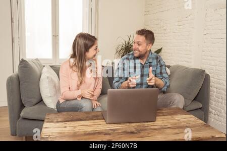 Life at home image of Happy couple video calling friends and family using laptop. Man and woman online chatting in video conference or live stream vir Stock Photo