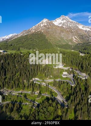 Dramatic aerial view of the Maloja mountain pass road in the Engadine valley in the alps in Canton Graubunden in Switzerland on a sunny summer day. Stock Photo