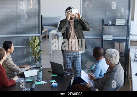 Portrait of diverse IT team developing software for virtual reality project, focus bearded man wearing VR headset in office Stock Photo