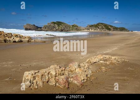 Scenic view of sandy beach and rocks at Robberg Nature Reserve, Plettenberg Bay, South Africa against blue sky Stock Photo