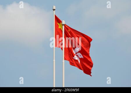 National flag of the People's Republic of China flying alongside the flag of the Hong Kong Special Administrative Region Stock Photo