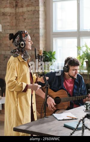 Couple of artists performing together in recording studio Stock Photo
