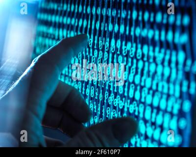 Network Security, Hand about to touch a computer screen with data streaming through Stock Photo