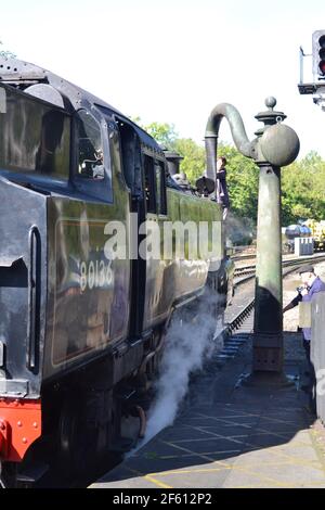 Steam Train Being Filled With Water At Pickering Station On NYMR On A Sunny Afternoon - Heritage Railway Line - Yorkshire - UK Stock Photo