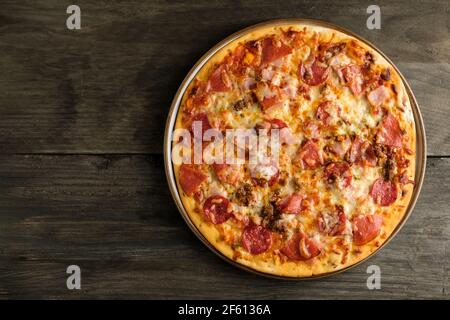 A home baked meat feast, stone baked thin crust pizza. Fresh out the oven its freshly baked with mozzarella cheese melting across the top Stock Photo