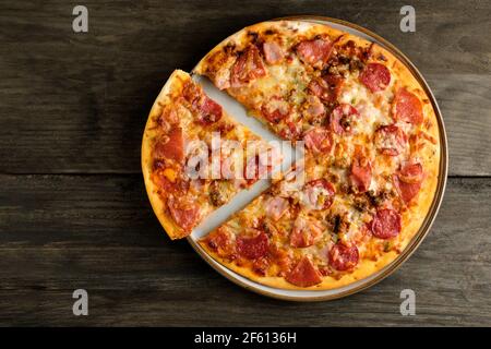 A home baked meat feast, stone baked thin crust pizza. Fresh out the oven its freshly baked with mozzarella cheese melting across the top Stock Photo