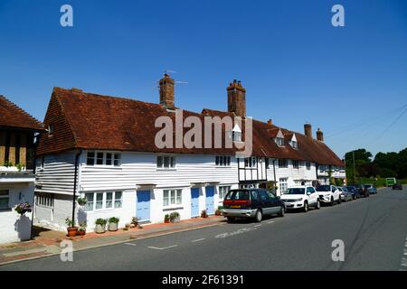 Typical white painted weatherboard and half timber framed cottages next to main road through village, Hartfield, East Sussex, England Stock Photo