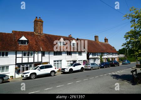 Typical white painted weatherboard and half timber framed cottages next to main road through village, Hartfield, East Sussex, England Stock Photo