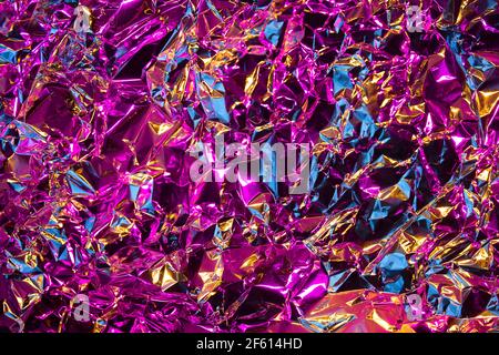 Fashion metal chrome texture of crumled silver foil with mix of pink, blues and gold colors. Modern background with iridescent effect. Shine metallic Stock Photo