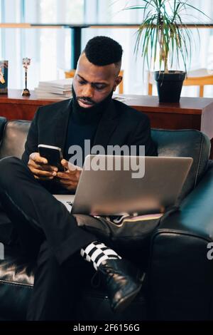 Businessman using smart phone while working in office Stock Photo