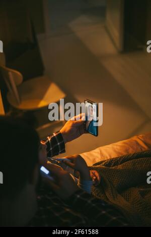 High angle view of sick man online consulting through video call on smart phone at home Stock Photo