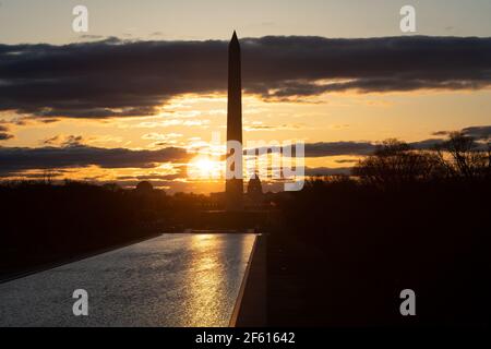 The sunrise is seen over the National Mall and U.S. Capitol Building, in Washington, D.C., at dawn on Monday, March 29, 2021, amid the coronavirus pandemic. Last week President Biden committed to a new goal of 200 million vaccine doses in his first hundred days in office, as American public health experts warn a new wave of COVID-19 cases may be starting as infection numbers rise in many areas of the country (Graeme Sloan/Sipa USA) Stock Photo