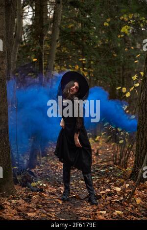 Fashion photo of woman with with creative make up in a forest. Fantasy. Halloween concept. Young beautiful and mysterious woman in woods Stock Photo