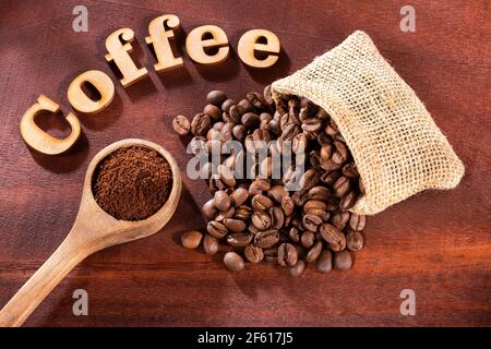 Ground and roasted coffee beans - Coffee phrase in wood letters Stock Photo