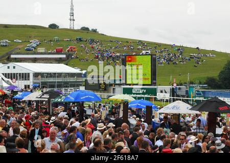 Bookies and racegoers  in the Gordon Enclosure, Goodwood Racecourse, Chichester, West Sussex, England, UK.  Spectators on Trundle Hil  ( iron age hill Stock Photo