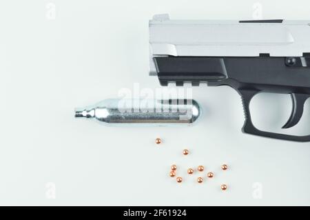 Air Gun, Co2 Cartridge and Pellets on a Grey Background. Stock Photo