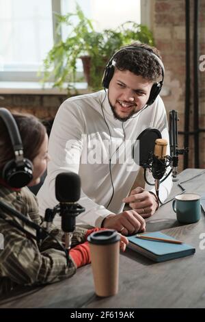 Young man in headphones interviewing the woman during air on the radio Stock Photo