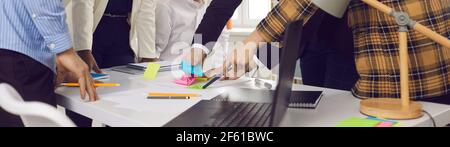 Close up of creative business team during a brainstorm writing notes on colored sticky stickers. Stock Photo