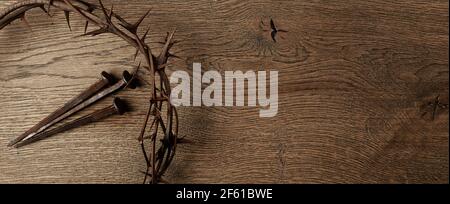 Crown of thorns with three nails on wooden background. Easter concept. Stock Photo