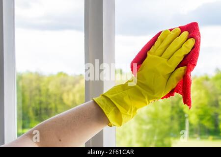 Window cleaning. A young woman sprays a cleaner on glass. Housework concept. Stock Photo