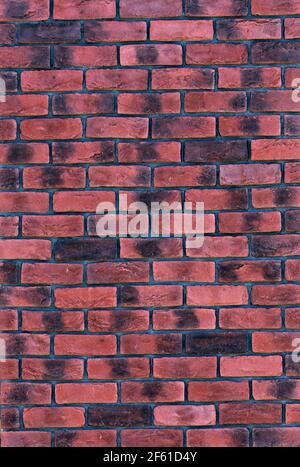 Red black brick wall with black seams, vertical brick background, copy space, building exterior, wall texture Stock Photo