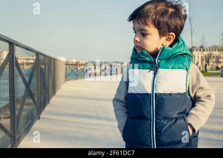 Portrait of little boy wearing sleeveless jacket, child looking away from camera Stock Photo