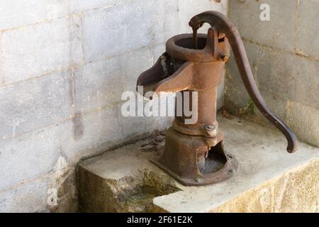 Ancient rusty pump for water flow on the street Stock Photo