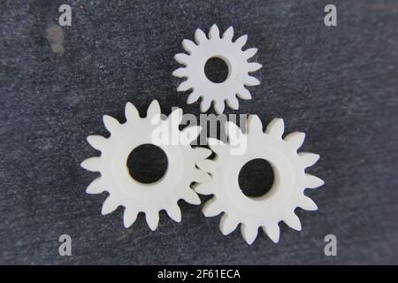 Gear, isolated of white plastic, on slate stone Stock Photo