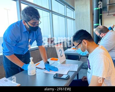 Frisco TX, USA - March 26, 2021: Close up view of hospital assistant helping people registering the covid-19 vaccine Stock Photo