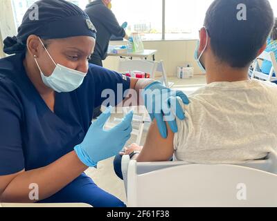 Frisco TX, USA - March 26, 2021: Close up view of Baylor Scott and White Hospital's nurse injecting the covid-19 vaccine to the patient Stock Photo