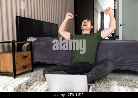 Handsome man wearing working using computer laptop very happy and excited doing winner gesture with arms raised, smiling and screaming for success. Ce Stock Photo