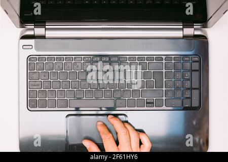 Aerial view of a laptop, with one hand operating the mouse Stock Photo