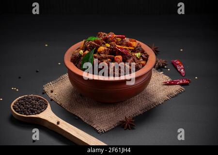 Beef roast or  pothu ulartheyadu, kerala special dish arranged in an earthenware in traditional way garnished with coconut pieces. Stock Photo