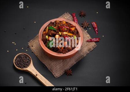 Beef roast or  pothu ulartheyadu, kerala special dish arranged in an earthenware in traditional way garnished with coconut pieces. Stock Photo
