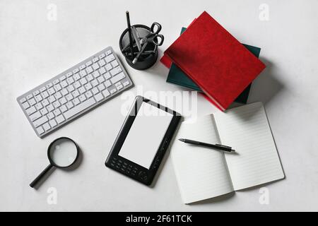 Composition with e-reader, computer keyboard and stationery on light background Stock Photo