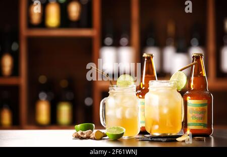 Bottles and mason jars  with fresh ginger beer on table in bar Stock Photo