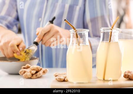 Bottles of healthy ginger juice on table in kitchen Stock Photo