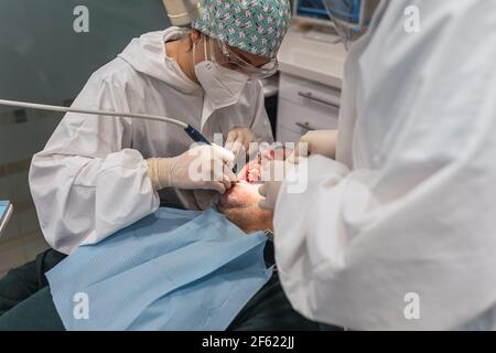 Female dentist with a patient in her office. Patient with open mouth and woman dentist working. dental health concept. Stock Photo