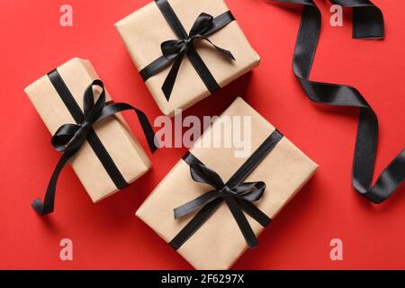 Gift boxes and black ribbons on color background Stock Photo