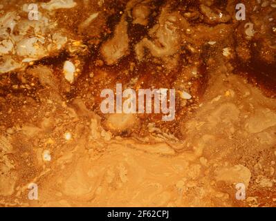 top view into bucket with glaze or paint, brown and beige abstract texture background Stock Photo