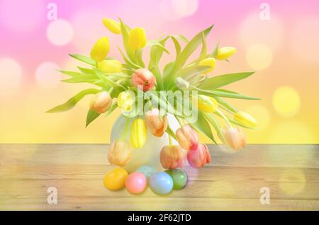 a bouquet of tulips in a white vase and Easter eggs Stock Photo