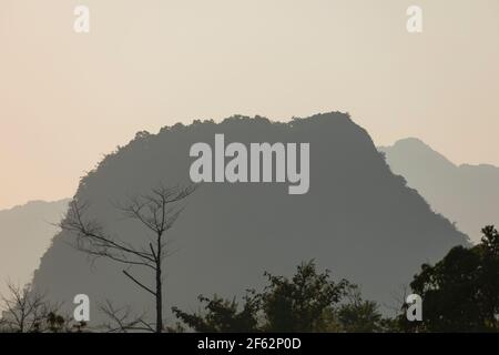 Landscape photography of karst mountains and their silhouettes, from the city of Vang Vieng, Laos, covered with forests formed by lush green tropical Stock Photo