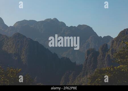 Landscape photography of karst mountains and their silhouettes, from the city of Vang Vieng, Laos, covered with forests formed by lush green tropical Stock Photo