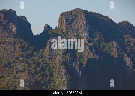 Landscape photography of karst mountains and their silhouettes, from the city of Vang Vieng, Laos, covered with forests formed by lush green tropical Stock Photo