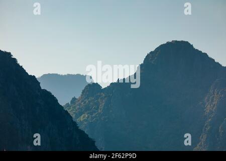 Landscape photography of karst mountains and their silhouettes, from the city of Vang Vieng, Laos, covered with forests formed by lush green tropical Stock Photo