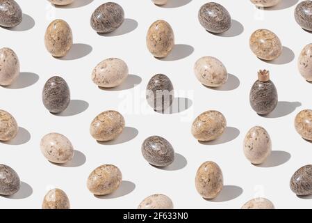 Pattern with decorated stone Easter eggs on light gray background. Minimal concept. Isometric layout. One egg in pattern with crown Stock Photo