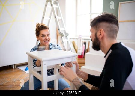Mid adults couple renovating furniture indoors at home, relocation and diy concept. Stock Photo