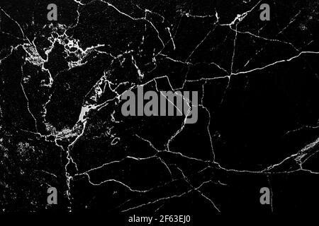 White cracks on a black background, texture with abstract patterns, marble or granite, decorative tile. Stock Photo