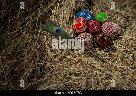 EASTER EGGS DECORATED  AS FABERGE EGGS IN A STRAW NEST WITH PEACOCK FEATHER Stock Photo